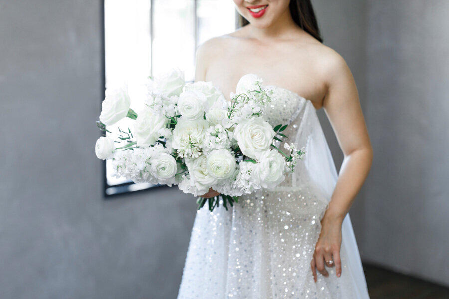Red lipstick, sparkly white wedding dress, white bridal bouquet.