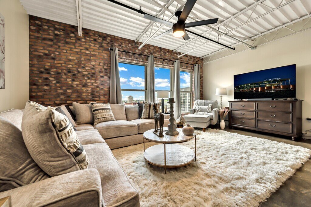 Spacious living room with plenty of seating and smart TV int his 2 bedroom, 2.5 bathroom luxury vacation rental loft condo for 8 guests with incredible downtown views, free parking, free wifi and professional decor in downtown Waco, TX.
