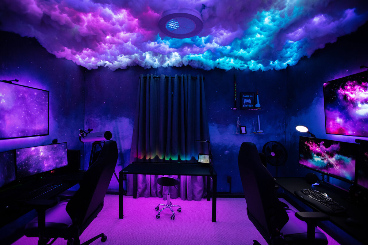 a gaming setup in a room with galaxy patterns on the walls