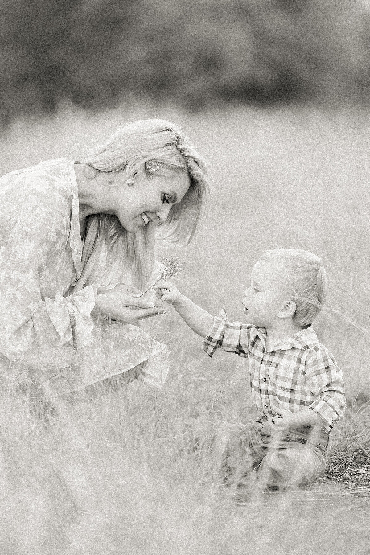 Black and white photo of a DFW mother holding a piece of grass her baby boy gave her.