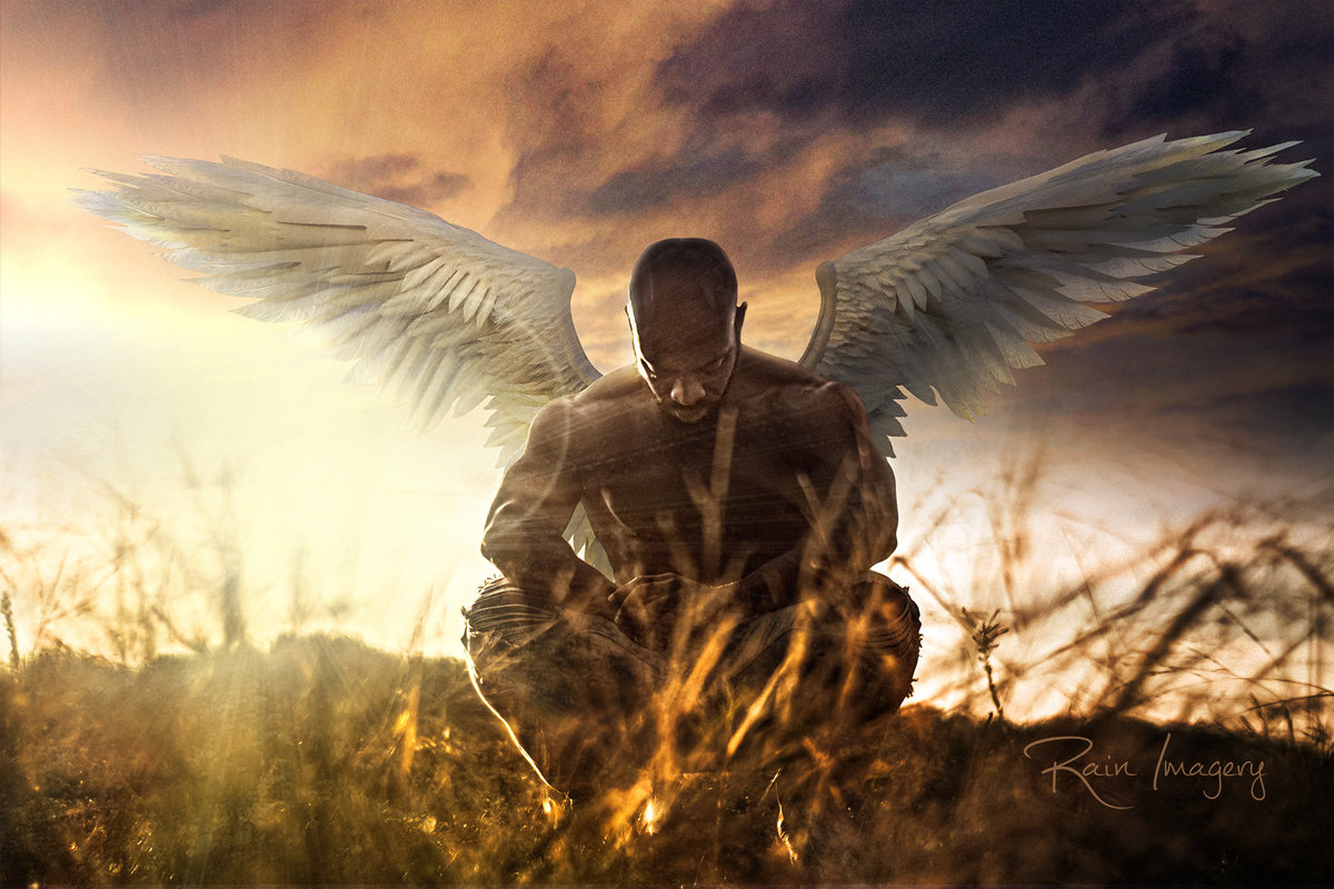 A black man with angel wings at sunrise on a hill in Virginia