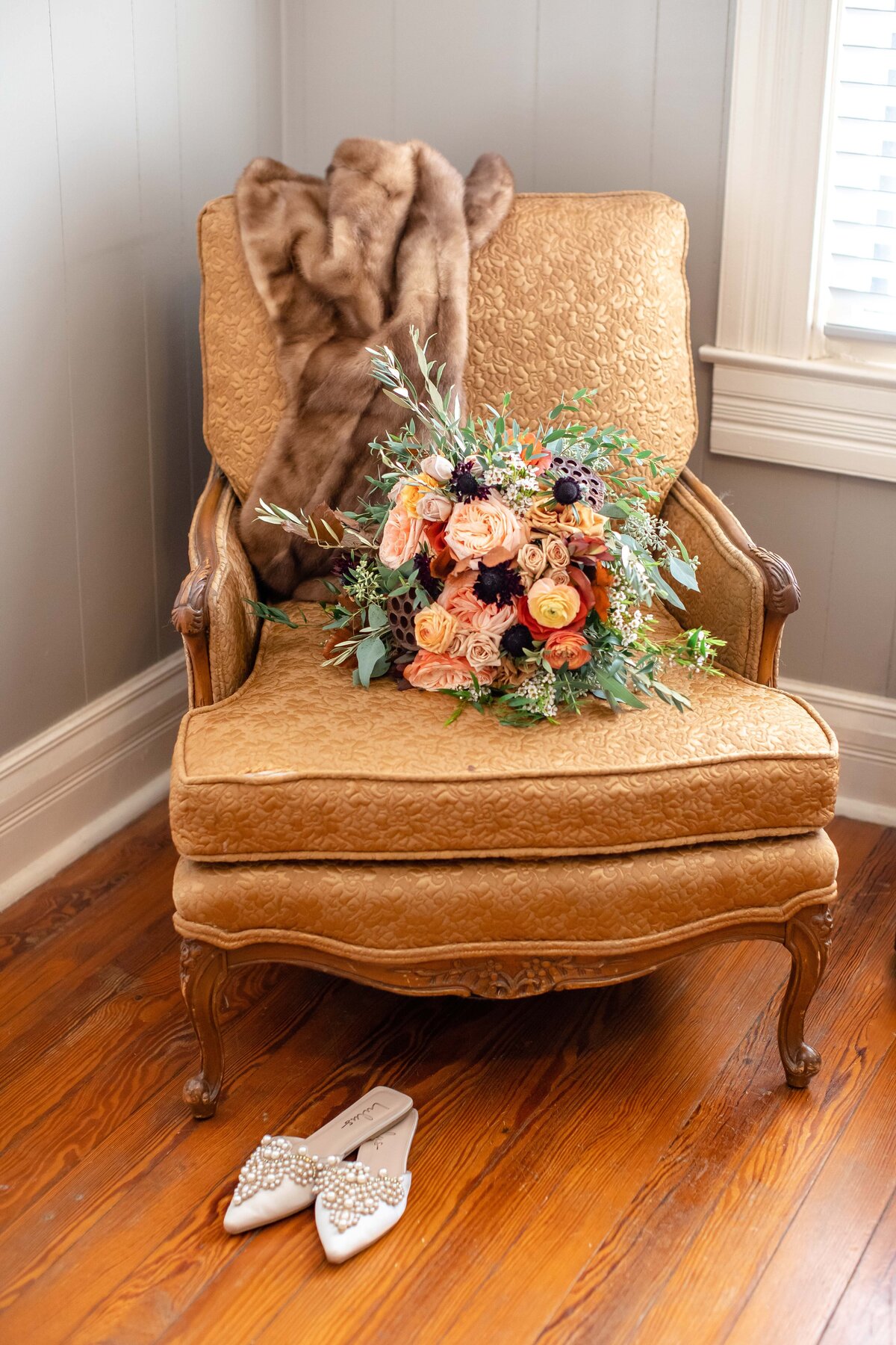antique chair fall bouquet and pearl slippers on wooden floor at Allen Farmhaus in New Braunfels Texas