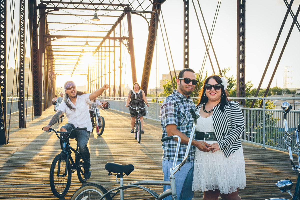 Engaged couple hanging out with their friend on Hays Street Bridge with their friends and bicycles.