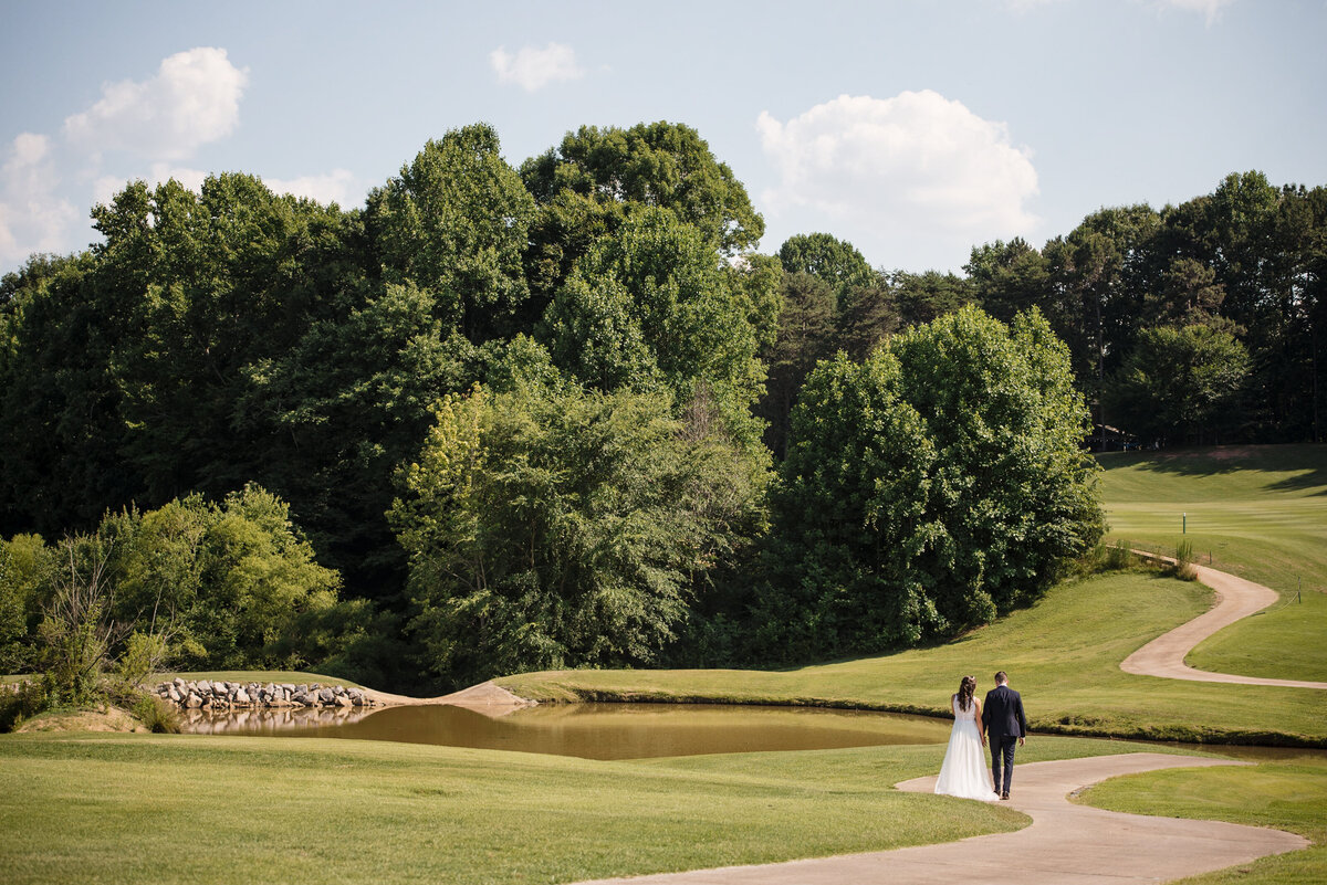 Wide-angle-image-of-a-bride-and-groom-small-in-the-frame-on-the-rolling-hills-of-NorthStone-Country-Clubs-golf-course