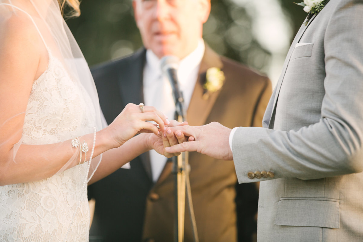 Bride puts on ring on grooms hand at Firestone Vineyard wedding