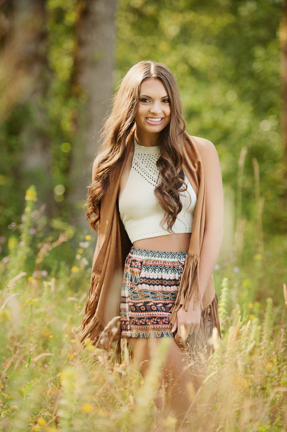 senior picture of girl with cardigan and patterned skirt in long grasses