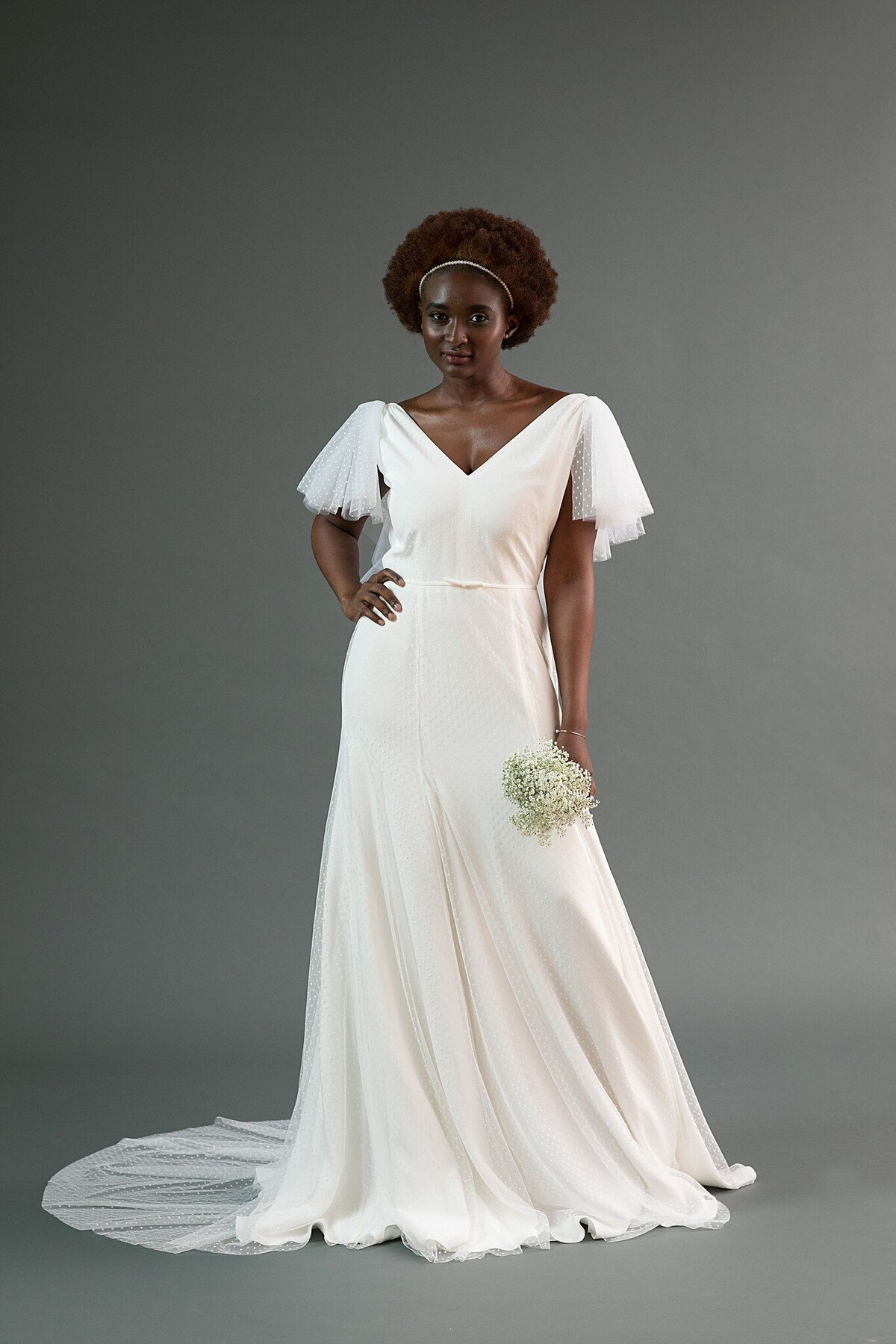 The Mai bridal style is a v-neck, modified a-line wedding dress in a crepe with a swiss dot net overlay.