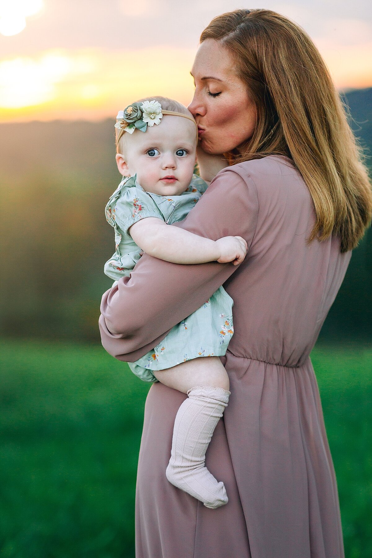 Mom kissing baby daughter at sunset near Harrisonburg, VA