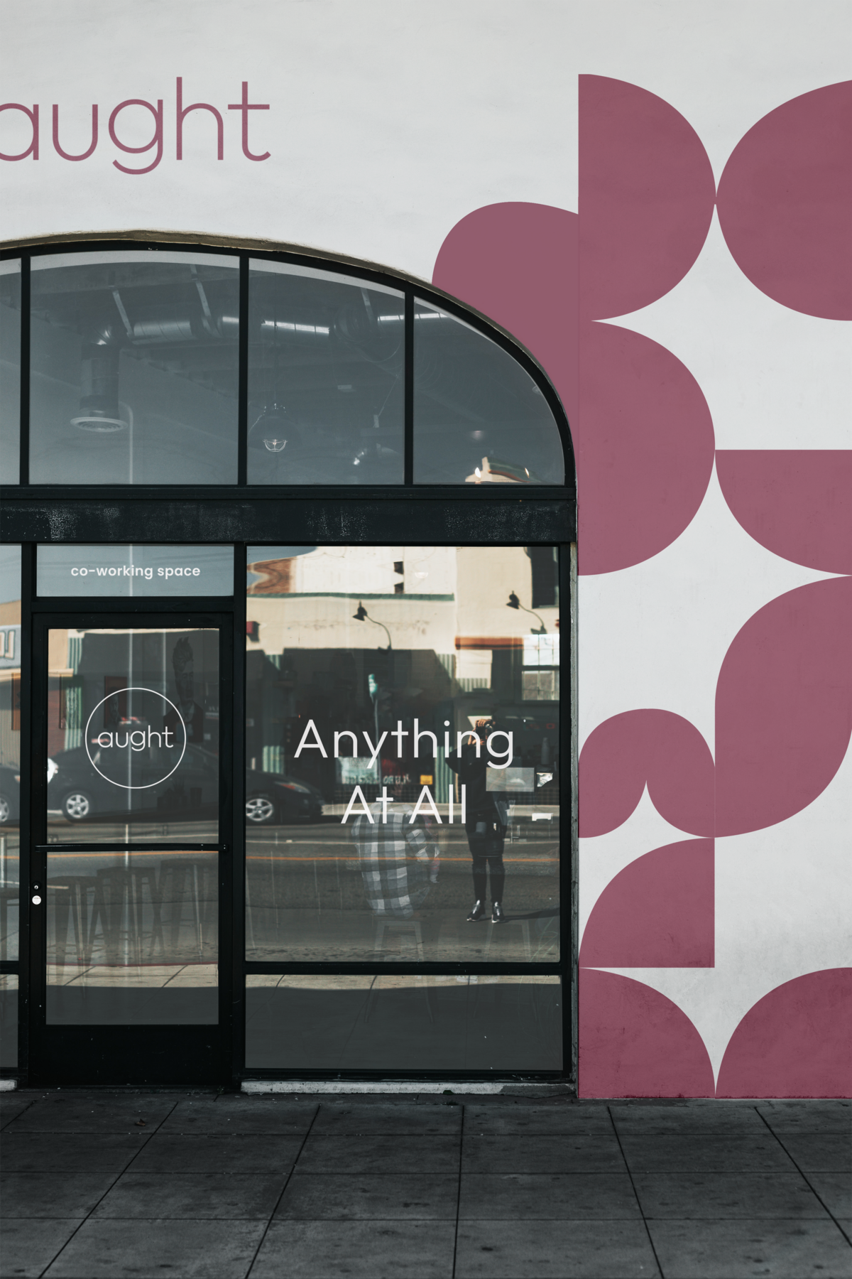 Brand identity for coworking space mocked up on front of building, windows, glass doors, with geometric brand pattern mural designed by Knoxville design agency Liberty Type