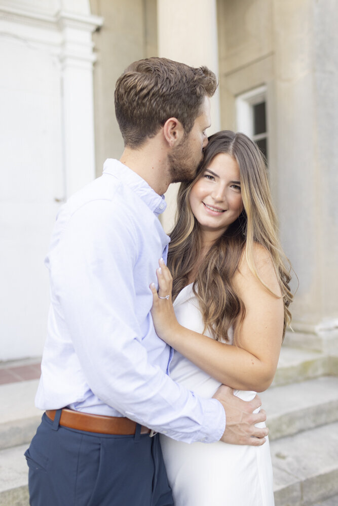 man kisses fiancee's forehead during engagement portraits sessions