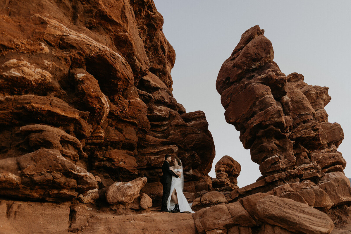 bride and groom standing together amungst the red rocks at garden of the gods