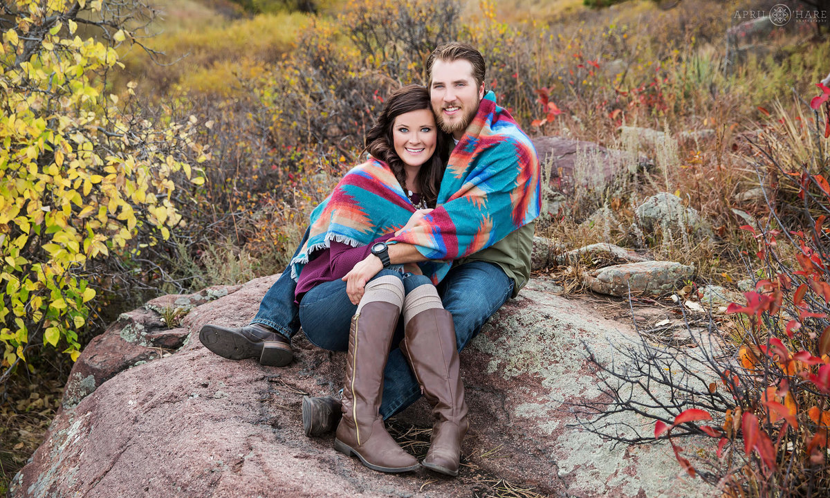 Snuggling up in printed blanket during Autumn at South Mesa trail Boulder Colorado Engagement Photography