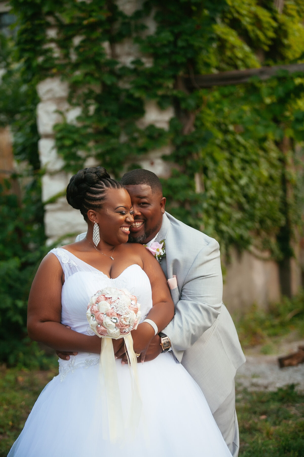 Black couple snuggles together at their summer wedding in St. Louis