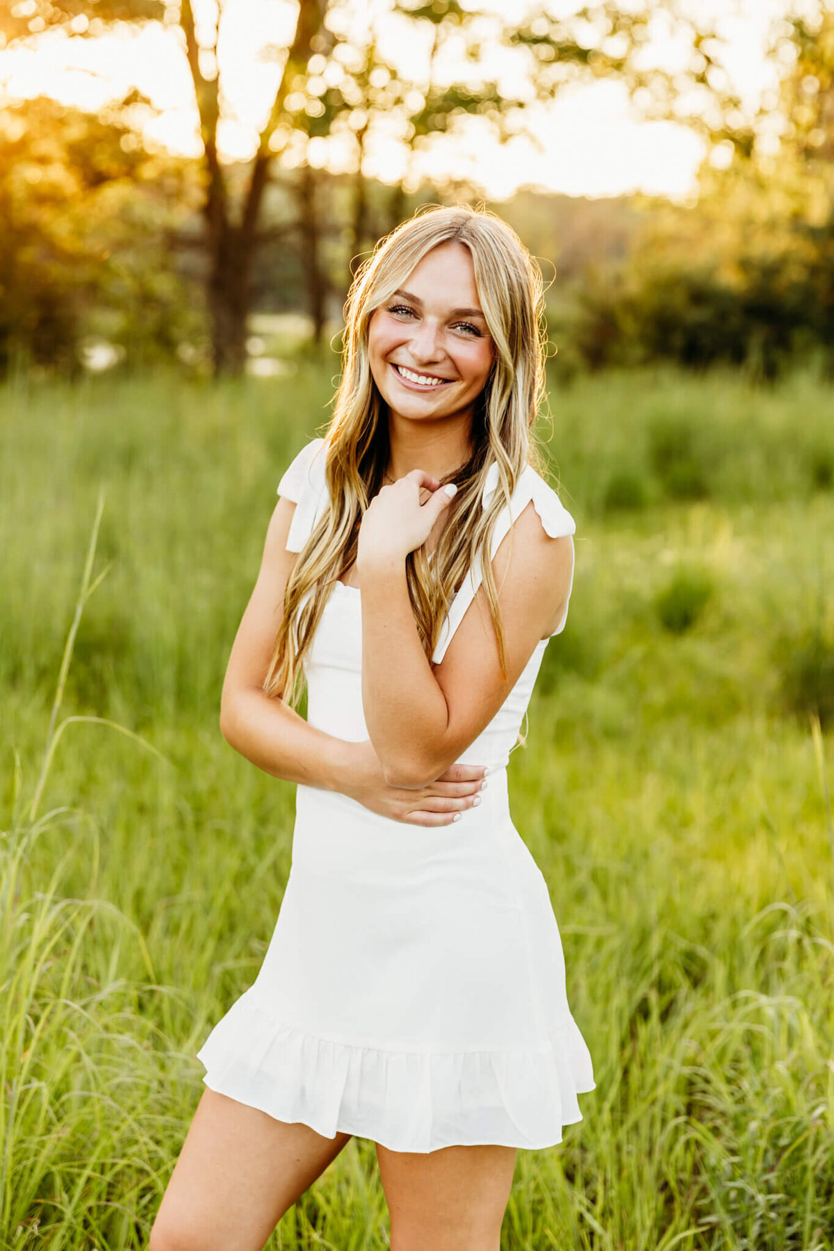 pretty teenage girl in a mini white dress playing with her hair and smiling for photo session with Ashley Kalbus