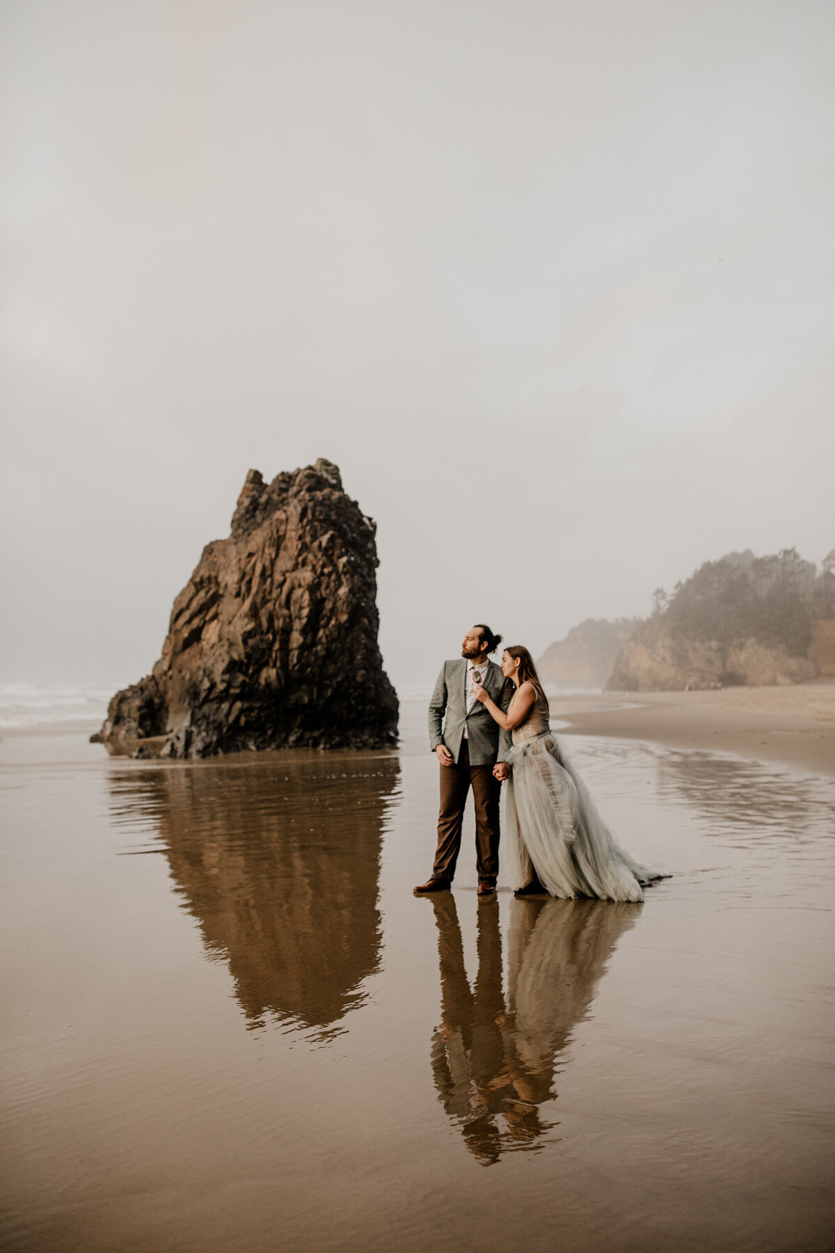 bride and groom walking by the ocean