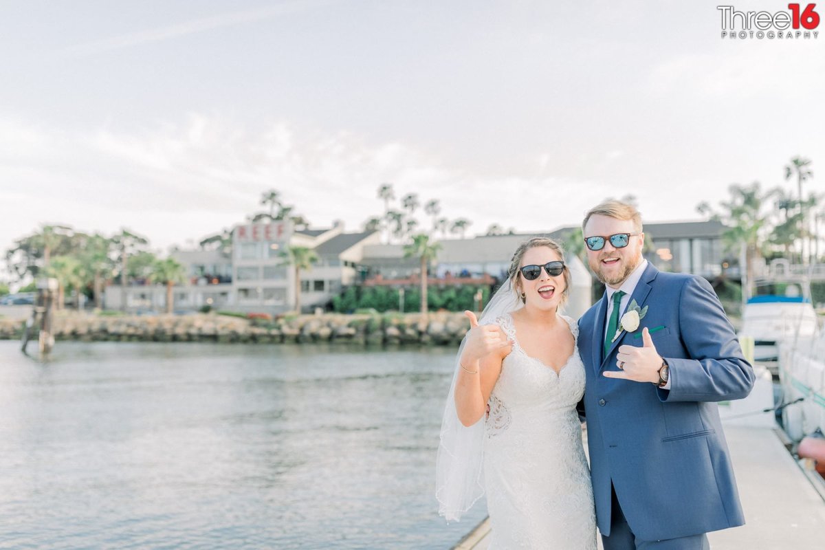 Bride and Groom share big smiles as they wear sunglasses and give the Hang Loose symbol with their hands