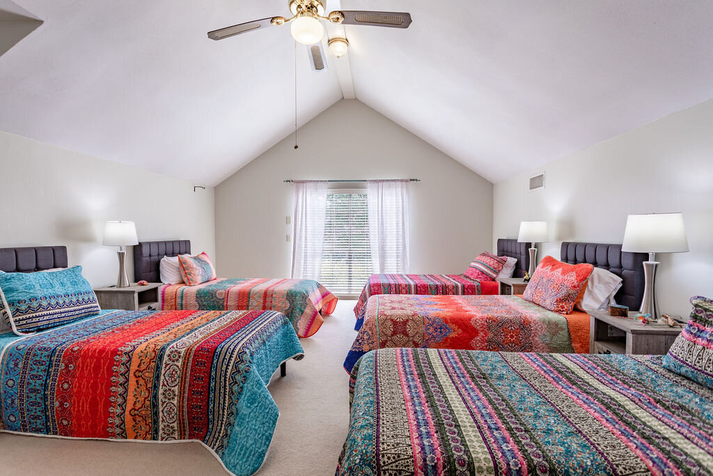 Bedroom with five beds and comfortable bedding in this 5-bedroom, 4-bathroom vacation rental house for 16+ guests with pool, free wifi, guesthouse and game room just 20 minutes away from downtown Waco, TX.