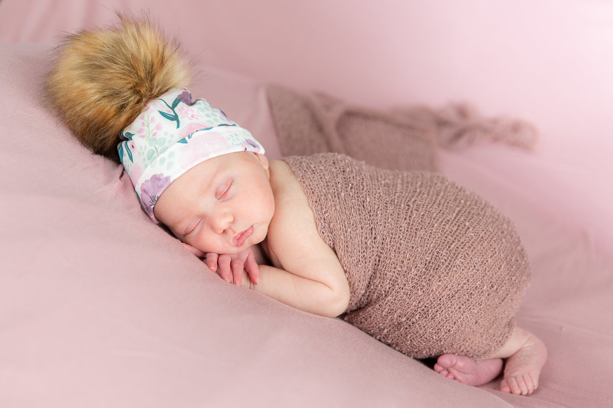 Newborn baby in faux fur hat