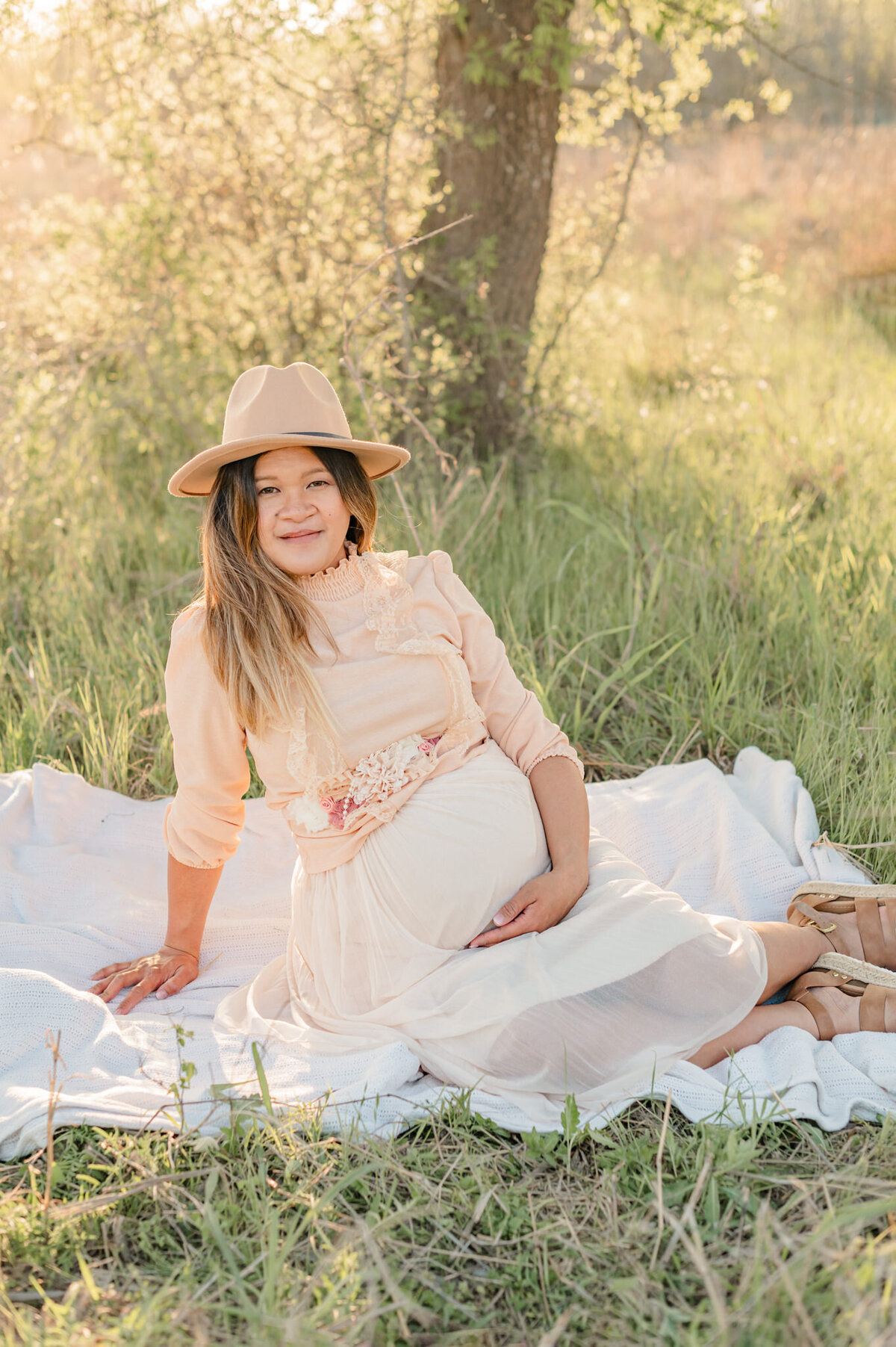 Expecting mom smiles at the camera, by San Antonio maternity photographer Cassie Golden.