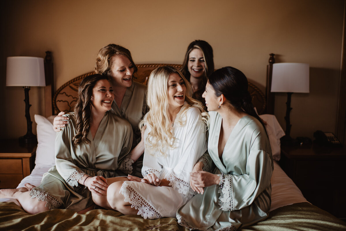 Photographers Jackson Hole capture bride laughing with groomsmen
