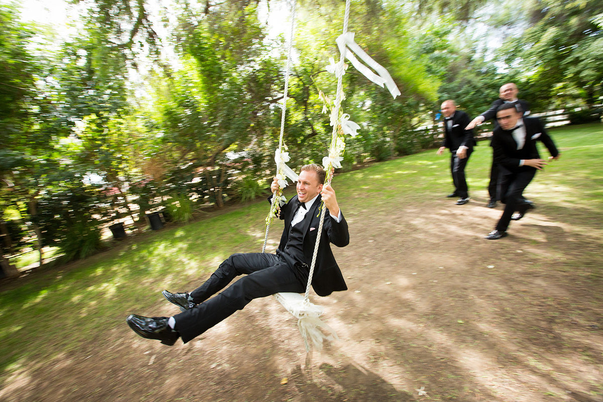 Twin Oaks wedding photos groom on swing laughing
