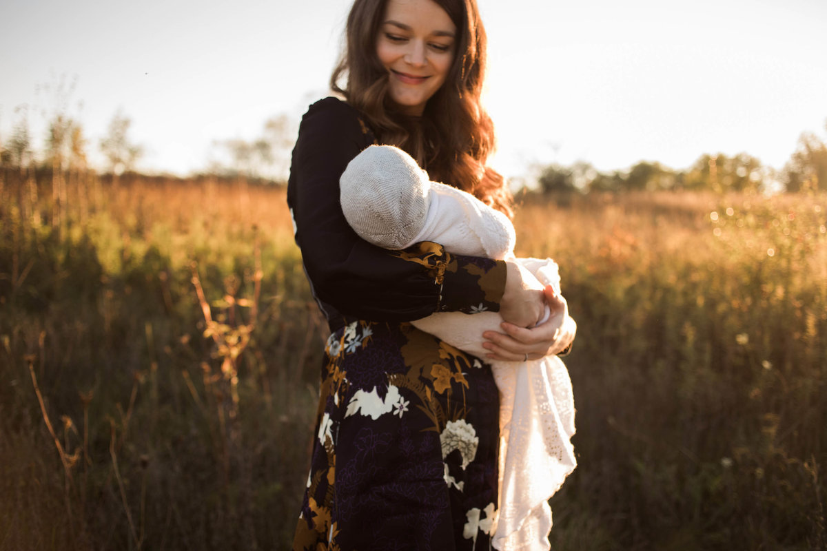 Laurie Baker captures a smiling mother with her beautiful newborn baby during sunset