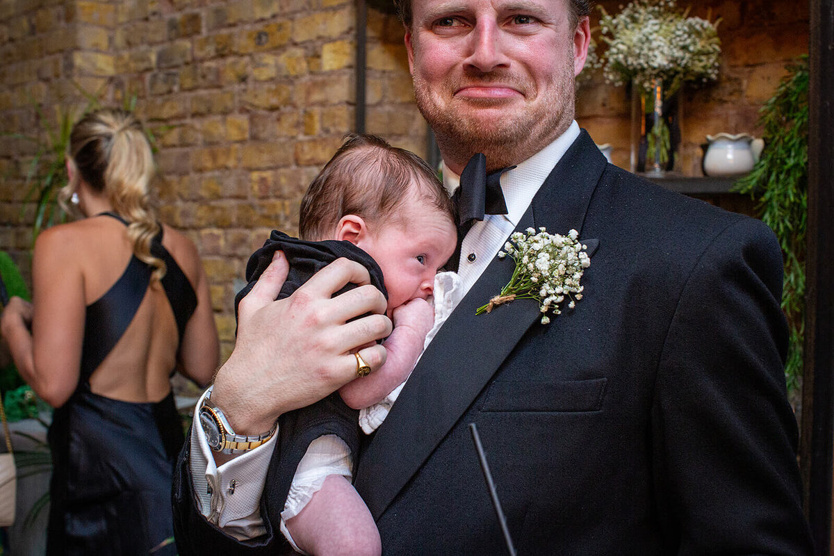 Grooms men holding baby at The Hackney Co