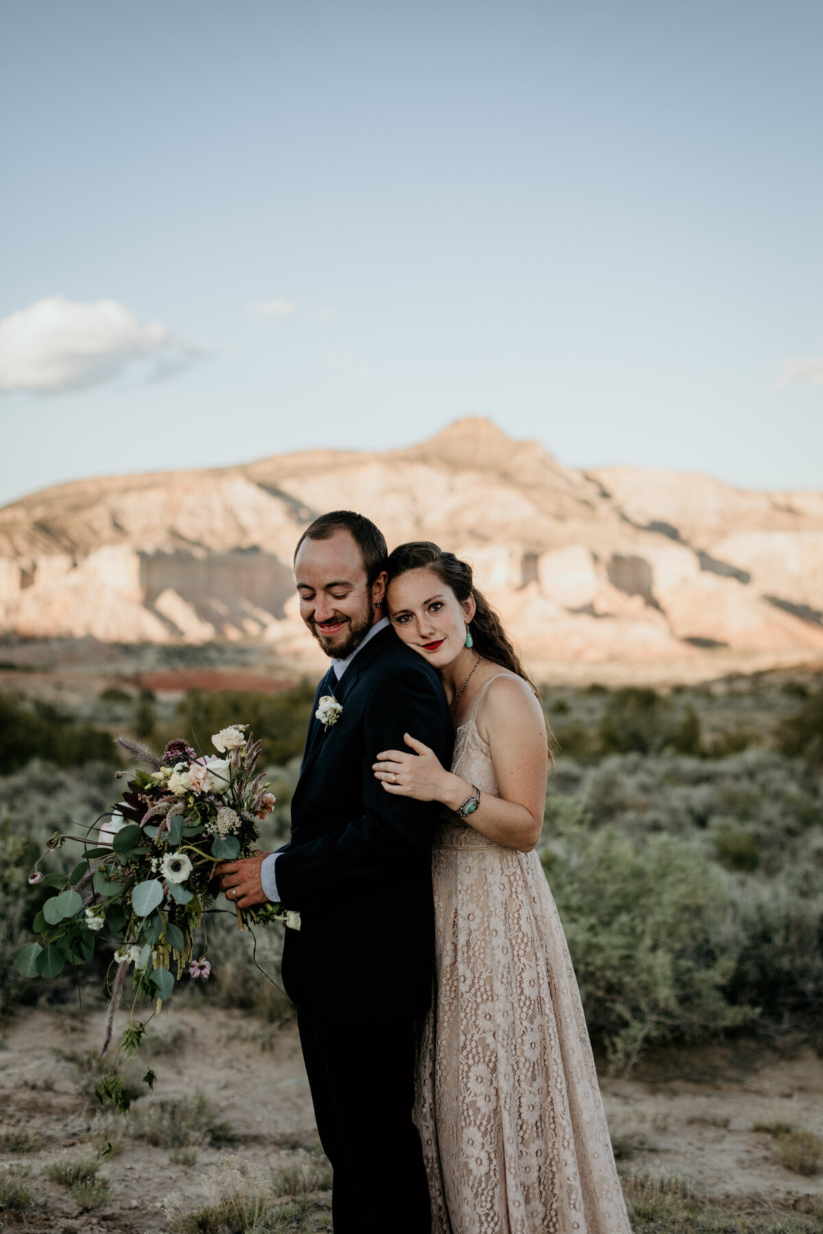 bride hugging groom from behind in New Mexico