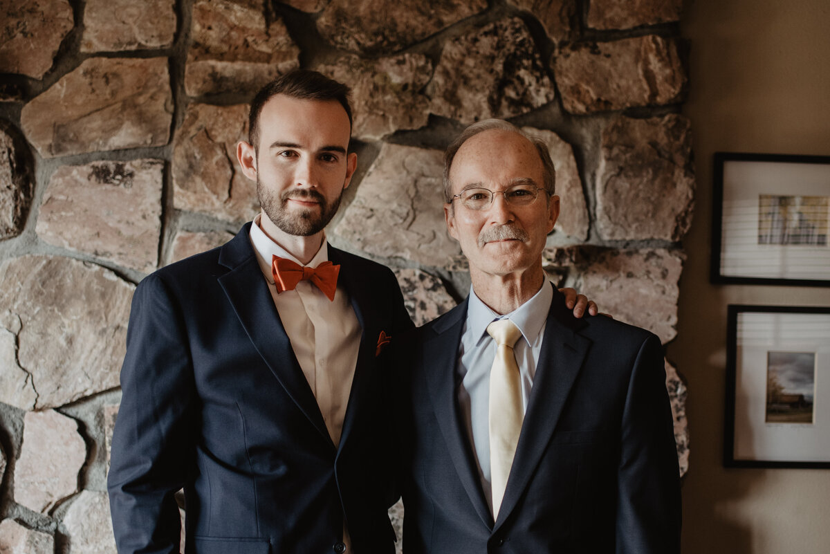 Photographers Jackson Hole capture groom standing with father during portraits before Grand Teton wedding