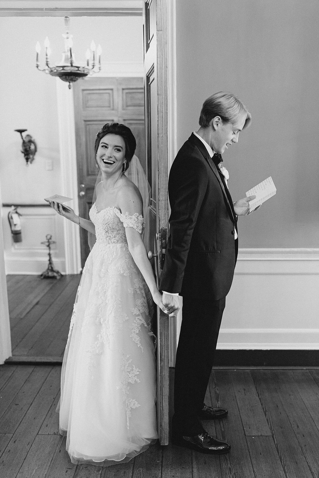 Private vow reading reaching around a door for first touch at William Aiken House wedding. Kailee DiMeglio Photography.
