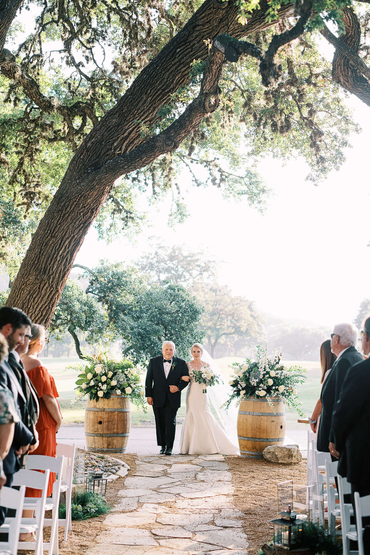 Bride walks down the aisle with her father at Tapatio Springs Hill Country Resort in Texas