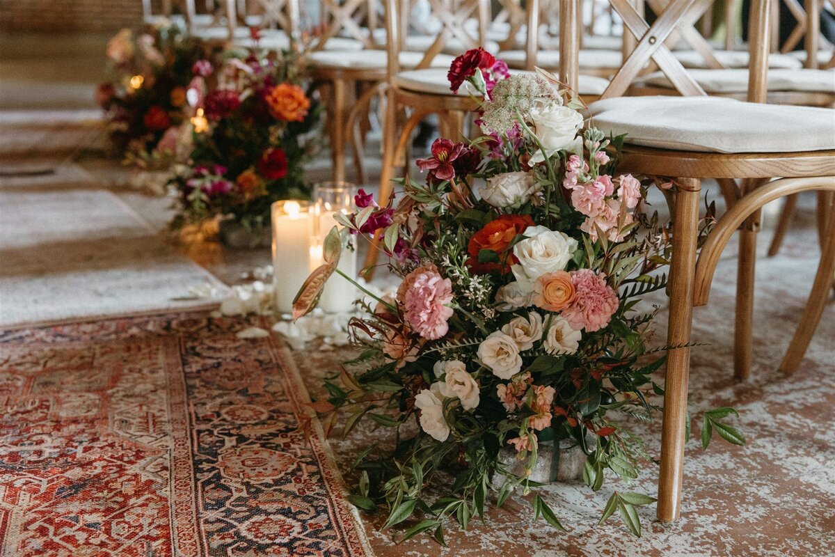 Wedding ceremony with colorful florals and candles , chandeliers at the St Vrain, wedding venue near Denver