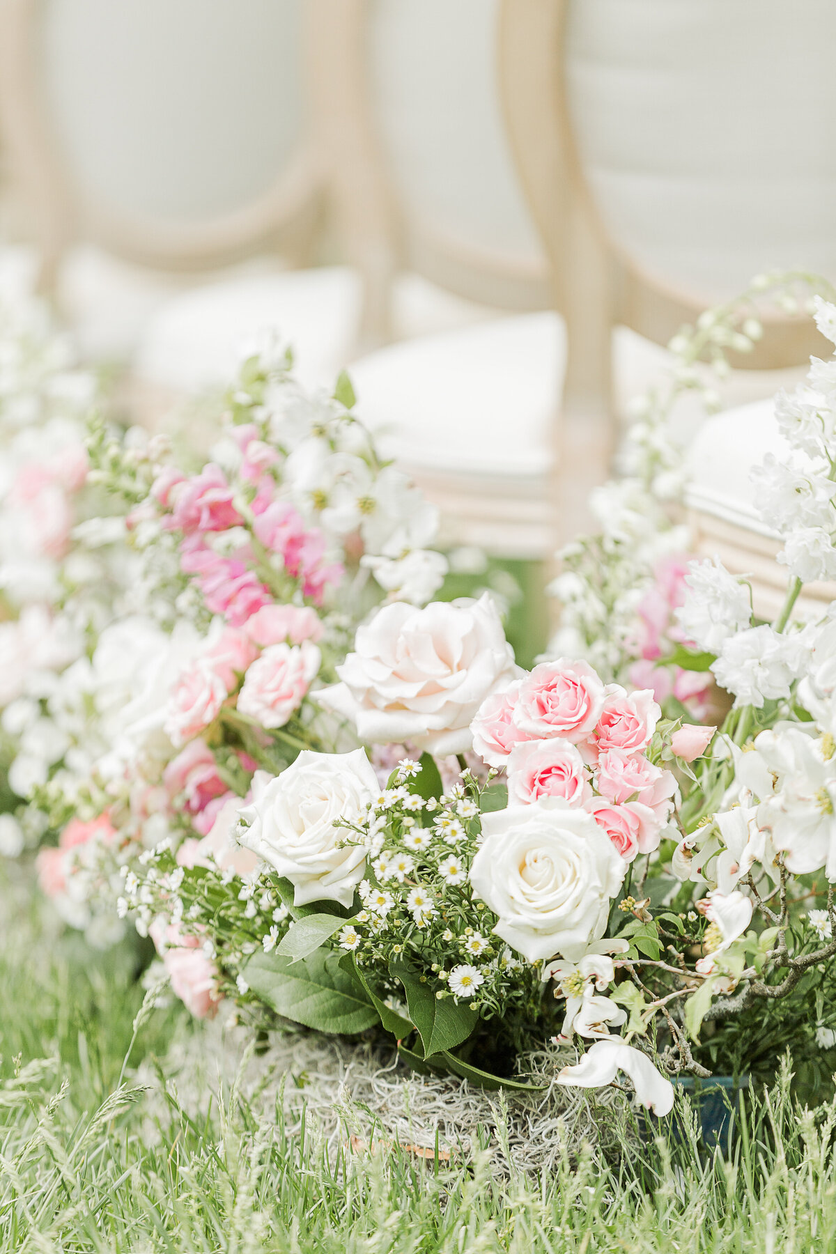 Detail image of flowers in grass alongside the wedding aisle.