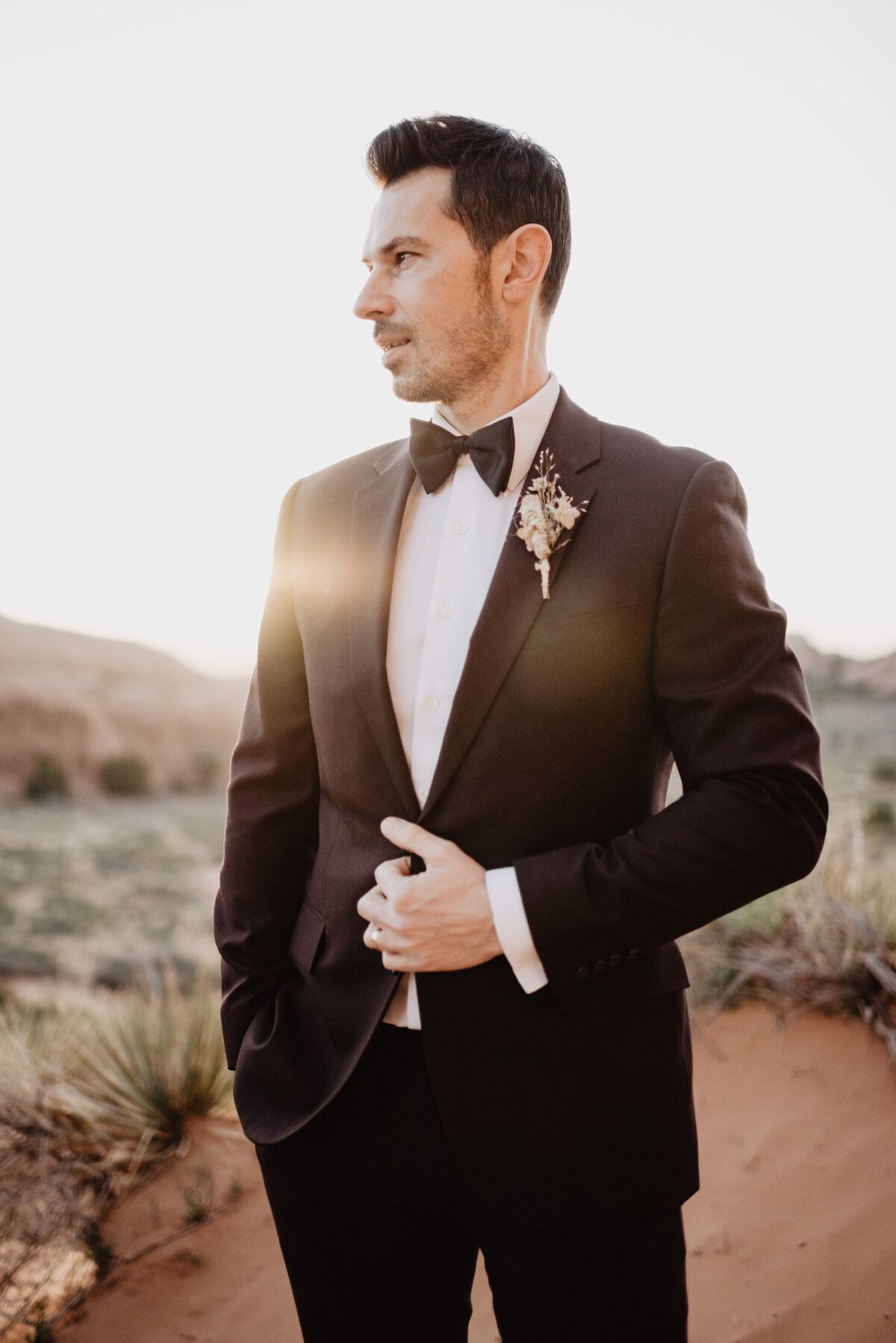 Utah elopement photographer captures groom looking away while holding jacket button
