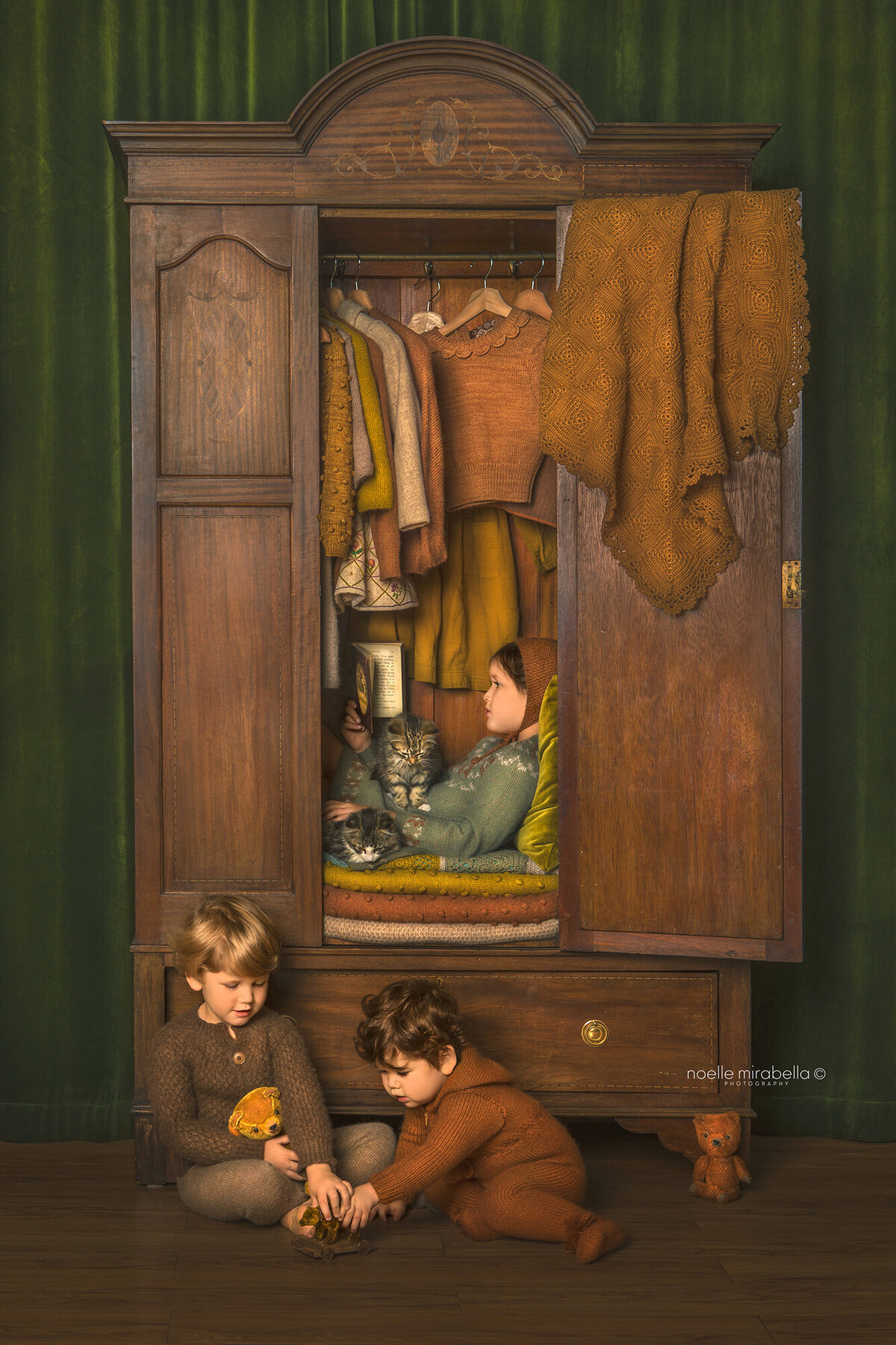 Children reading and playing in wardrobe full of clothes.