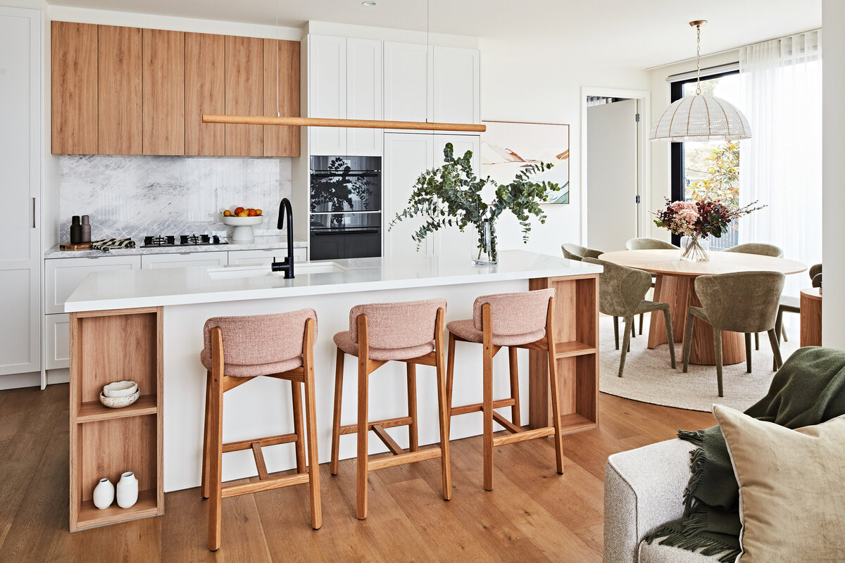 Light and airy kitchen with white stone island, oak joinery and blush bar stools