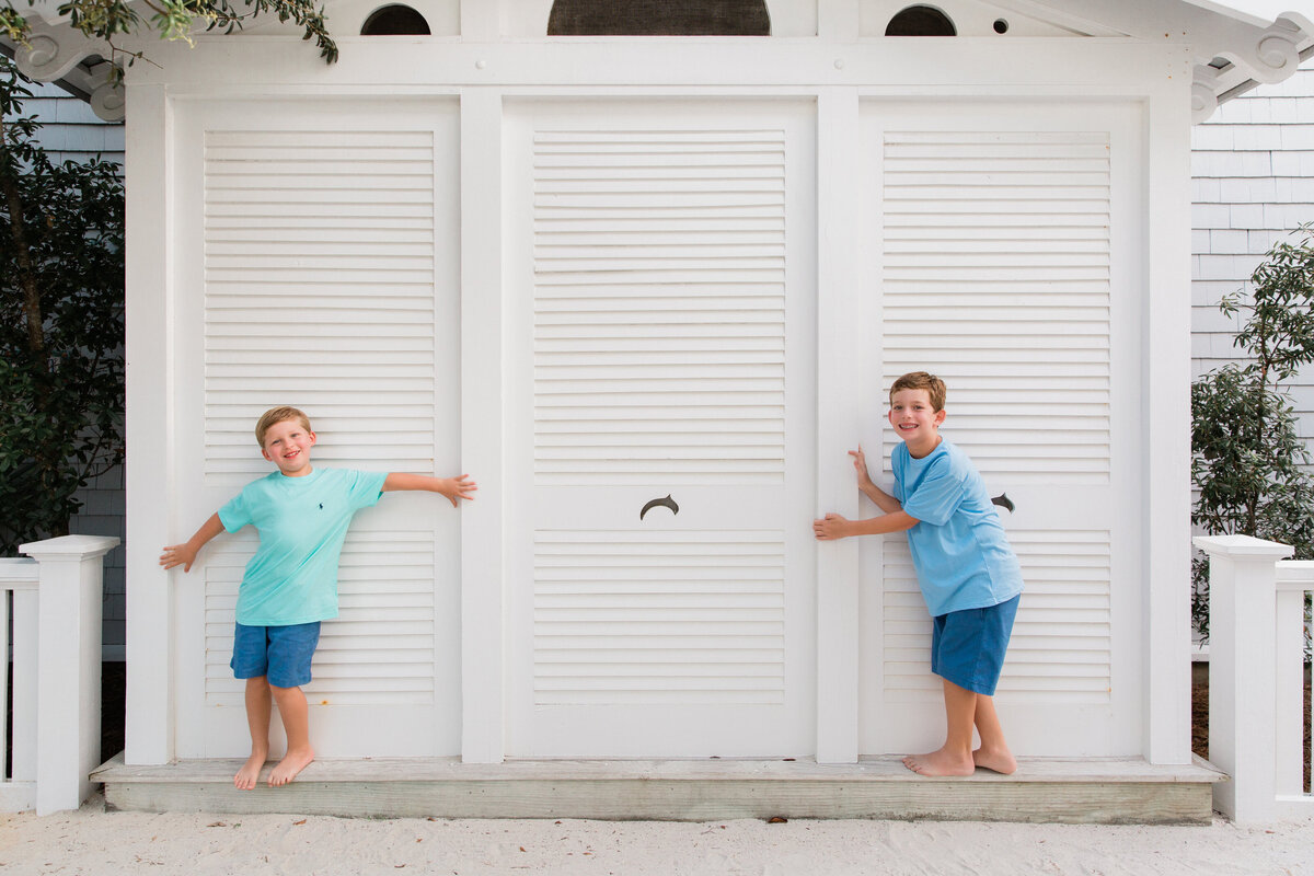 Two kids standing on a bench together smiling