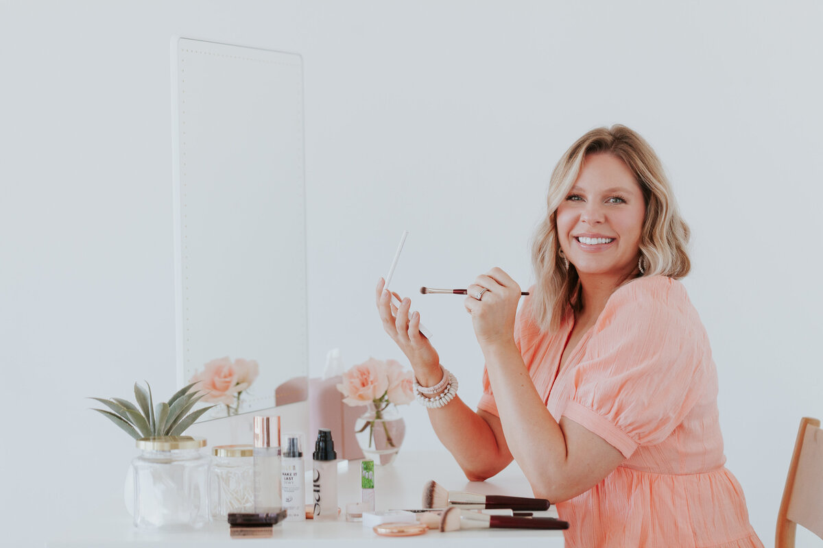 makeup-artist-portrait-holding-makeup-at-vanity-for-brand-session-the-frame-charlotte