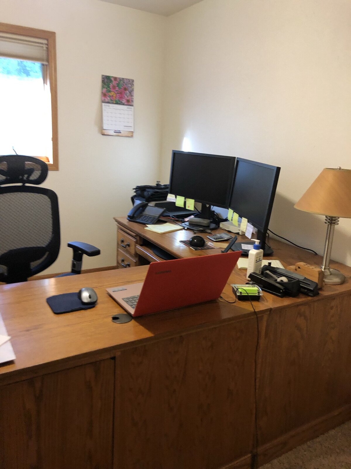 A large bulky corner office desk sits in a plain room