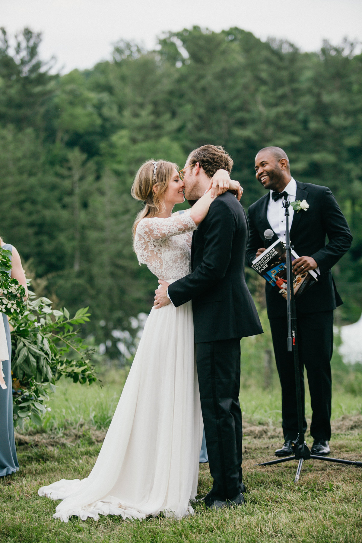 Newly wed couple share a kiss, in front of close family and friends.