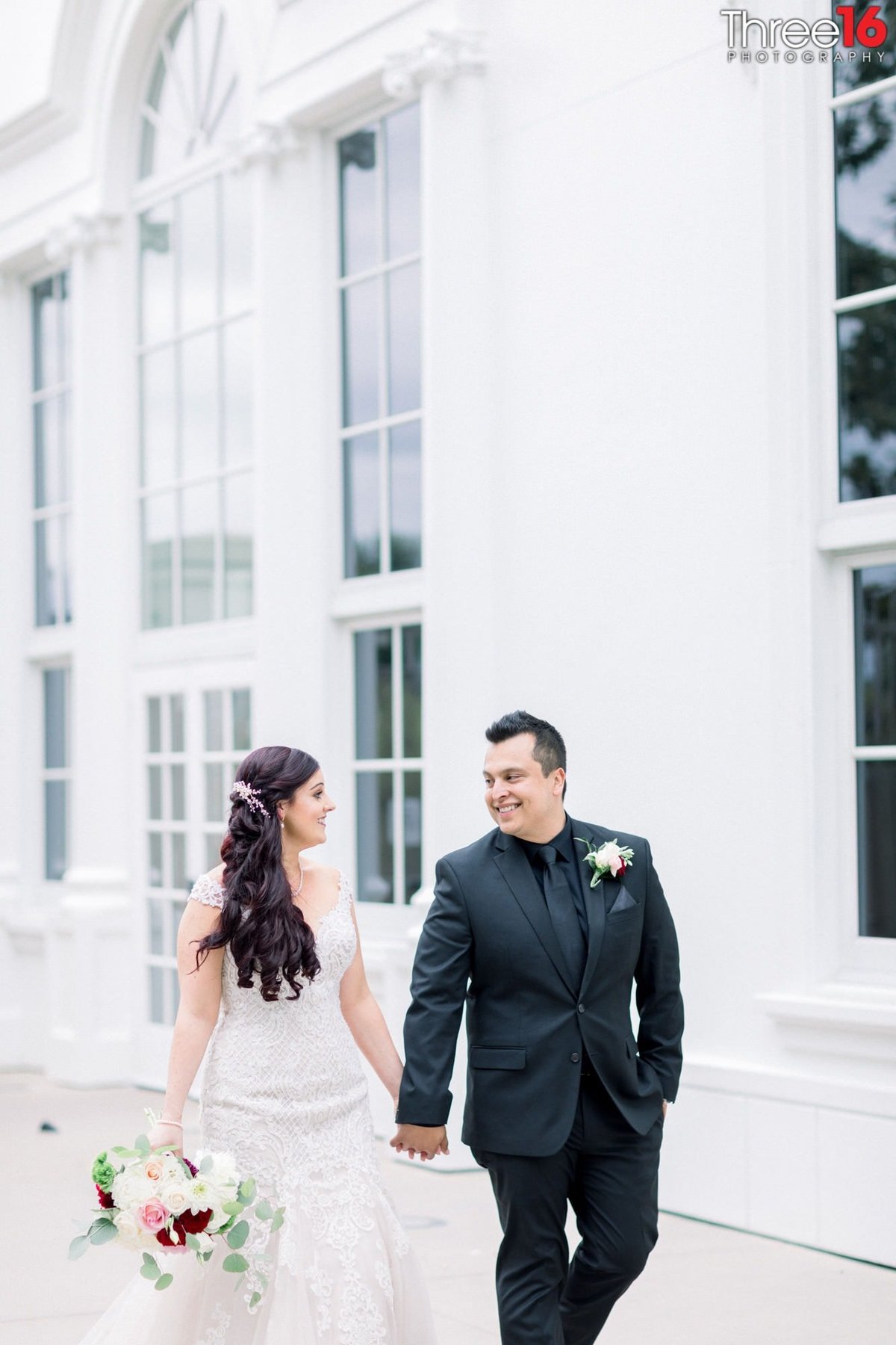 Bride and Groom smile at each other while holding hands