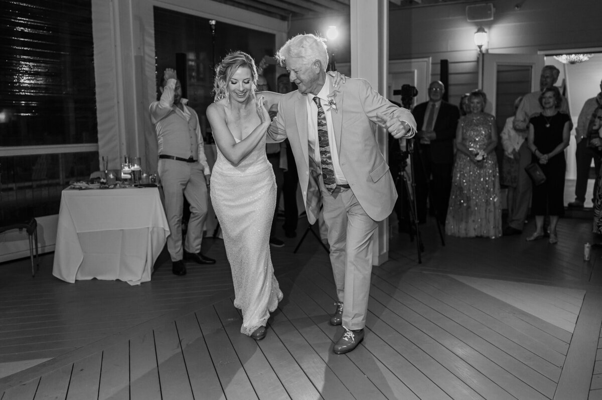 The father of the bride dancing the salsa with his daughter on her wedding day while enjoying their Raleigh wedding photography session by JoLynn Photography