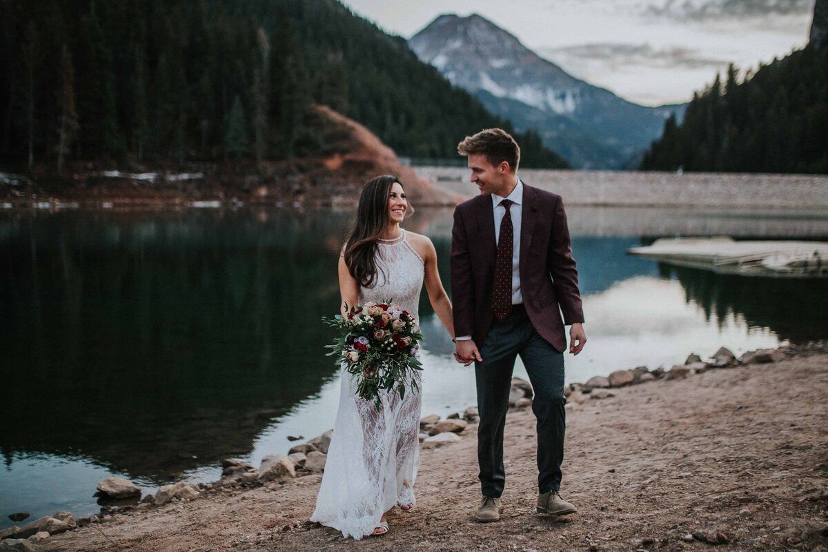Lake Tahoe wedding photographer captures bride and groom holding hands after beach wedding