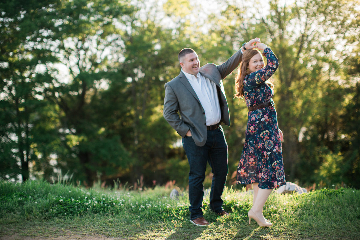 Wedding Photographer, couple dancing together in the grass and sun