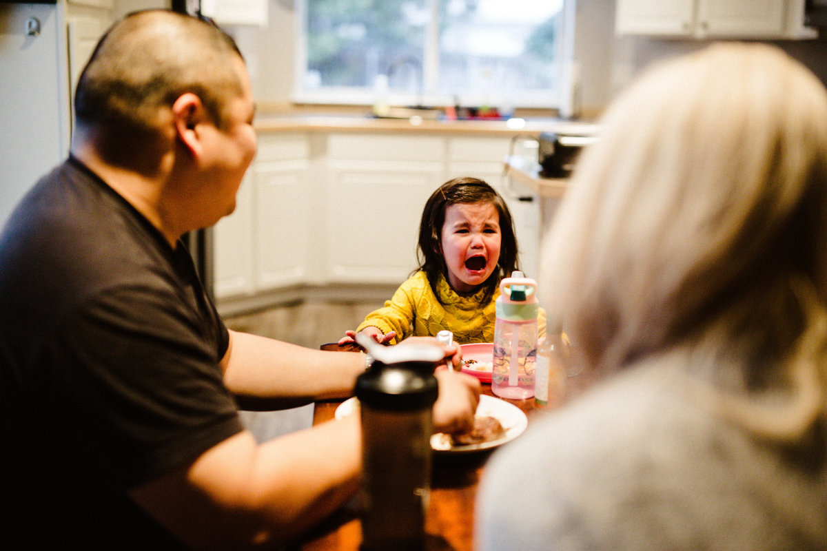 toddler girl screaming at dinner table