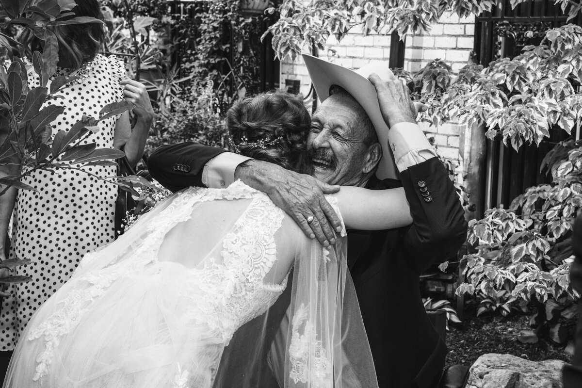 Bride hugs grandpa at wedding.