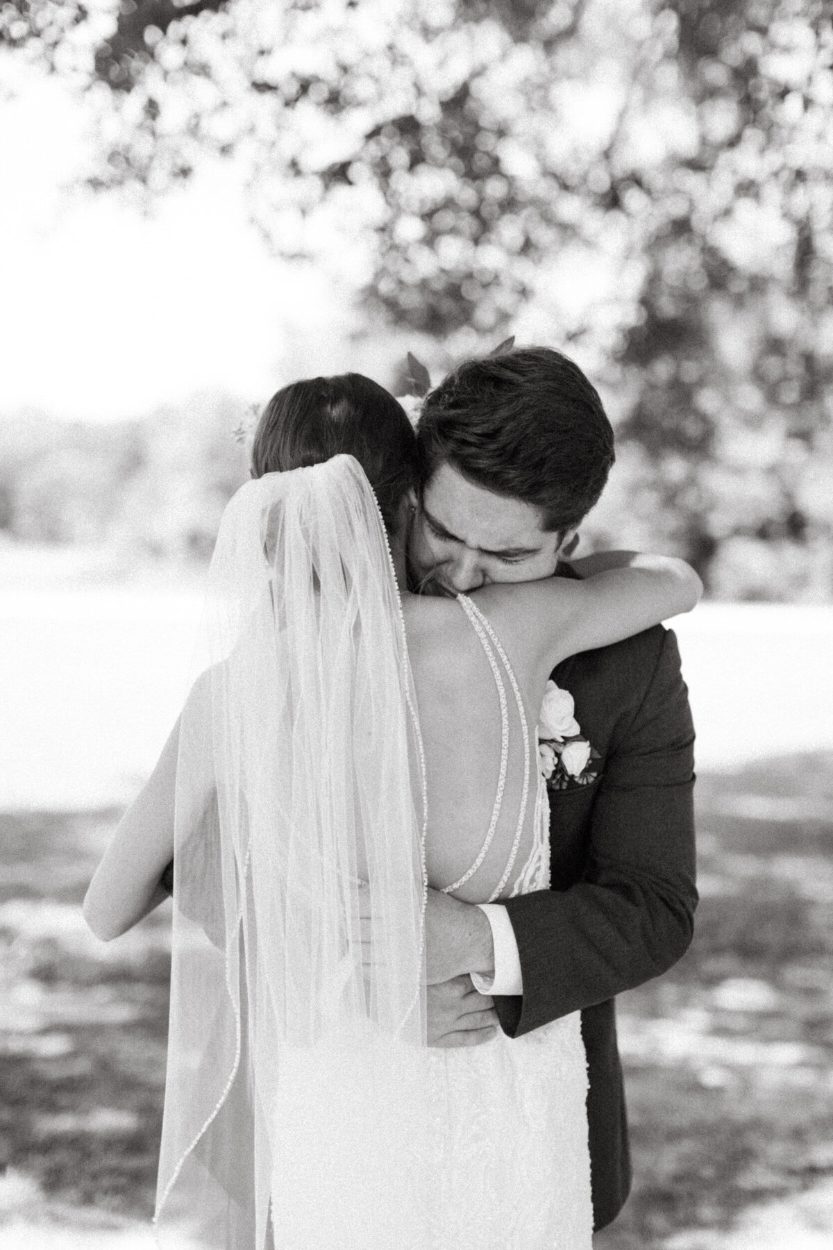 Groom crying as he grasps his bride tightly during their first look