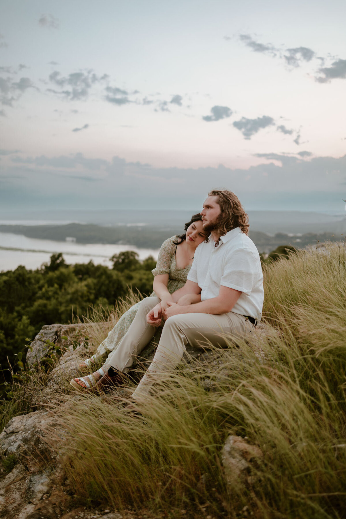 couple sitting on grassy hill
