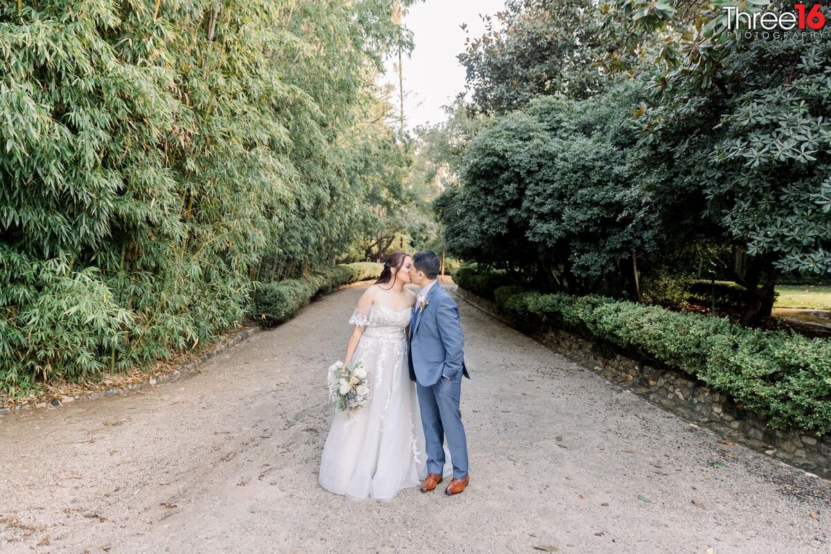 Bride and Groom share a kiss on a dirt path