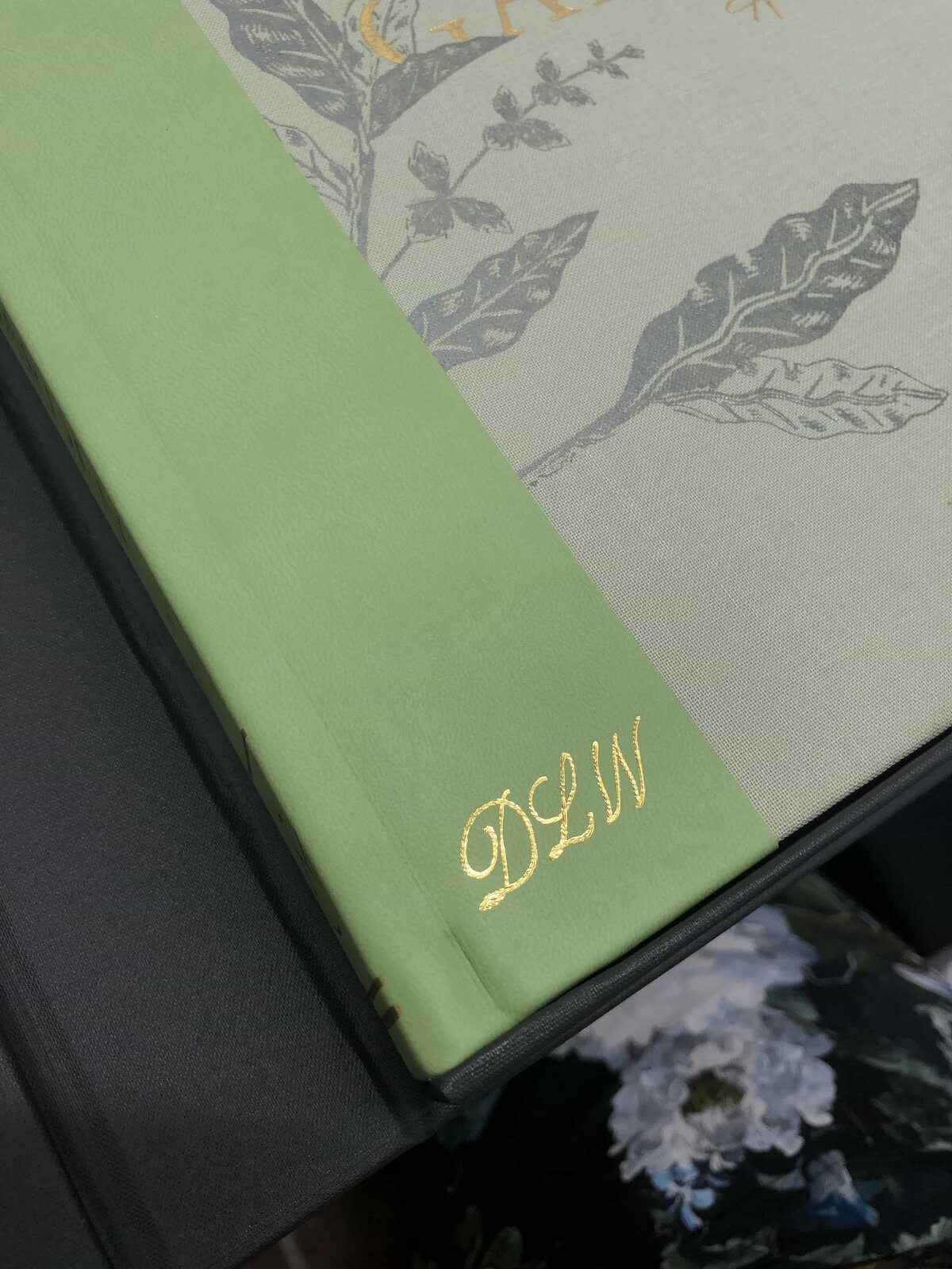 calligraphy monogram embossed in gold on a leather book cover